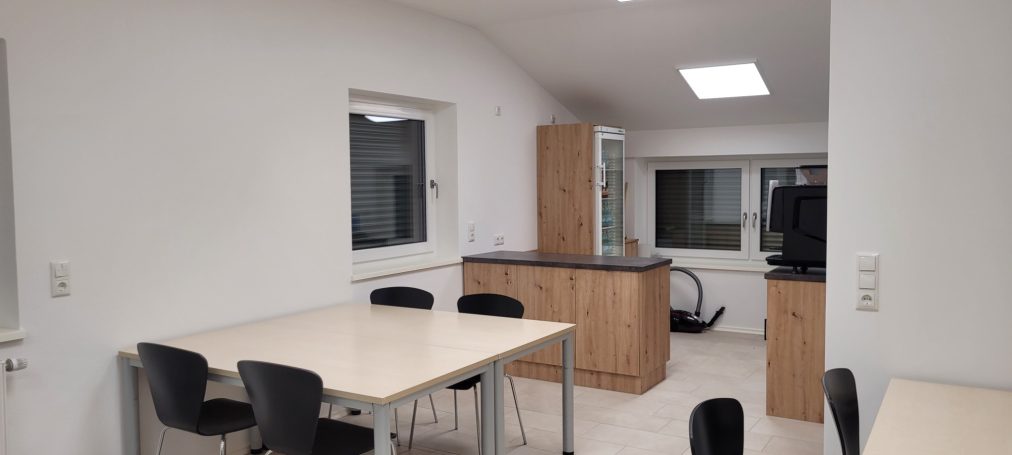 moderne Küche mit Tisch, Stühlen und Holzschränken. Helle, moderne Küche mit Tisch, Stühlen und Holzschränken.