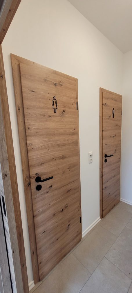WC Türen Zwei Holzinnentüren nebeneinander in einem hellen Flur.